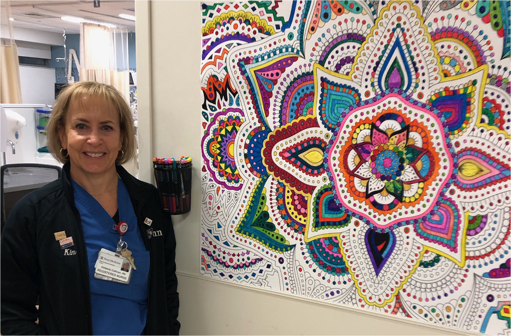 Nurse Kim Calhoun stands in front of a giant coloring sheet in the Perioperative Care Unit.